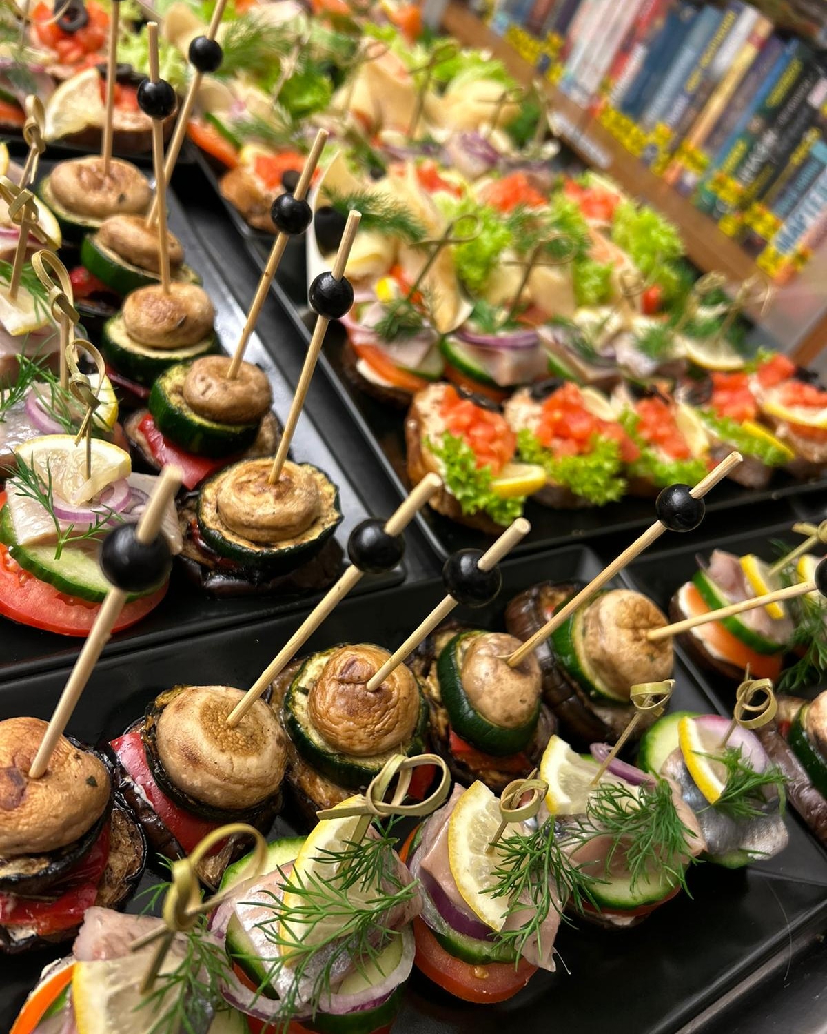 Fingerfood-Spieße auf schwarzen Platten